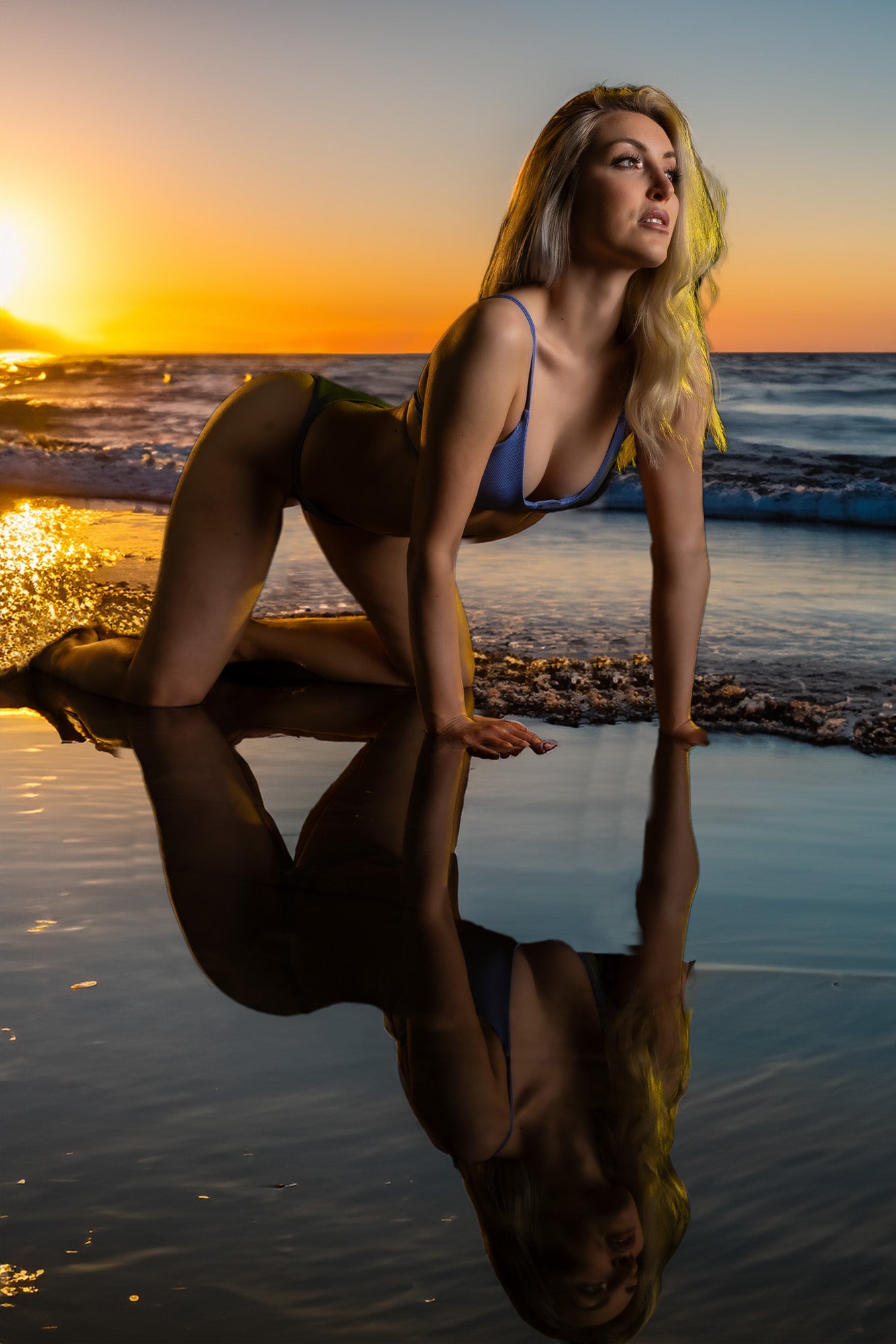 Boudoir pose at the shoreline with sunset reflections.