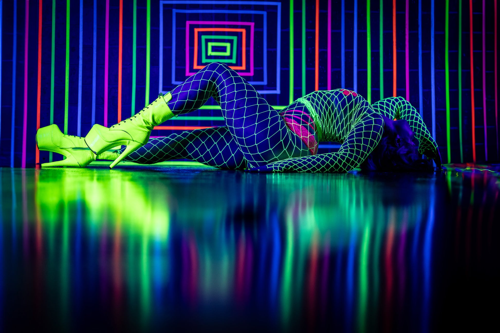 Blacklight boudoir image featuring rainbow lines and artistic floor posing at Studio SJ in Wisconsin.