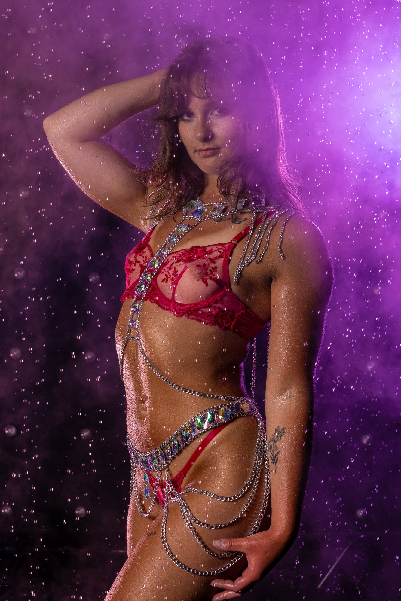 Boudoir rain-room portrait featuring soft pink mist, cascading water, and dramatic moody lighting for a cinematic, atmospheric effect.