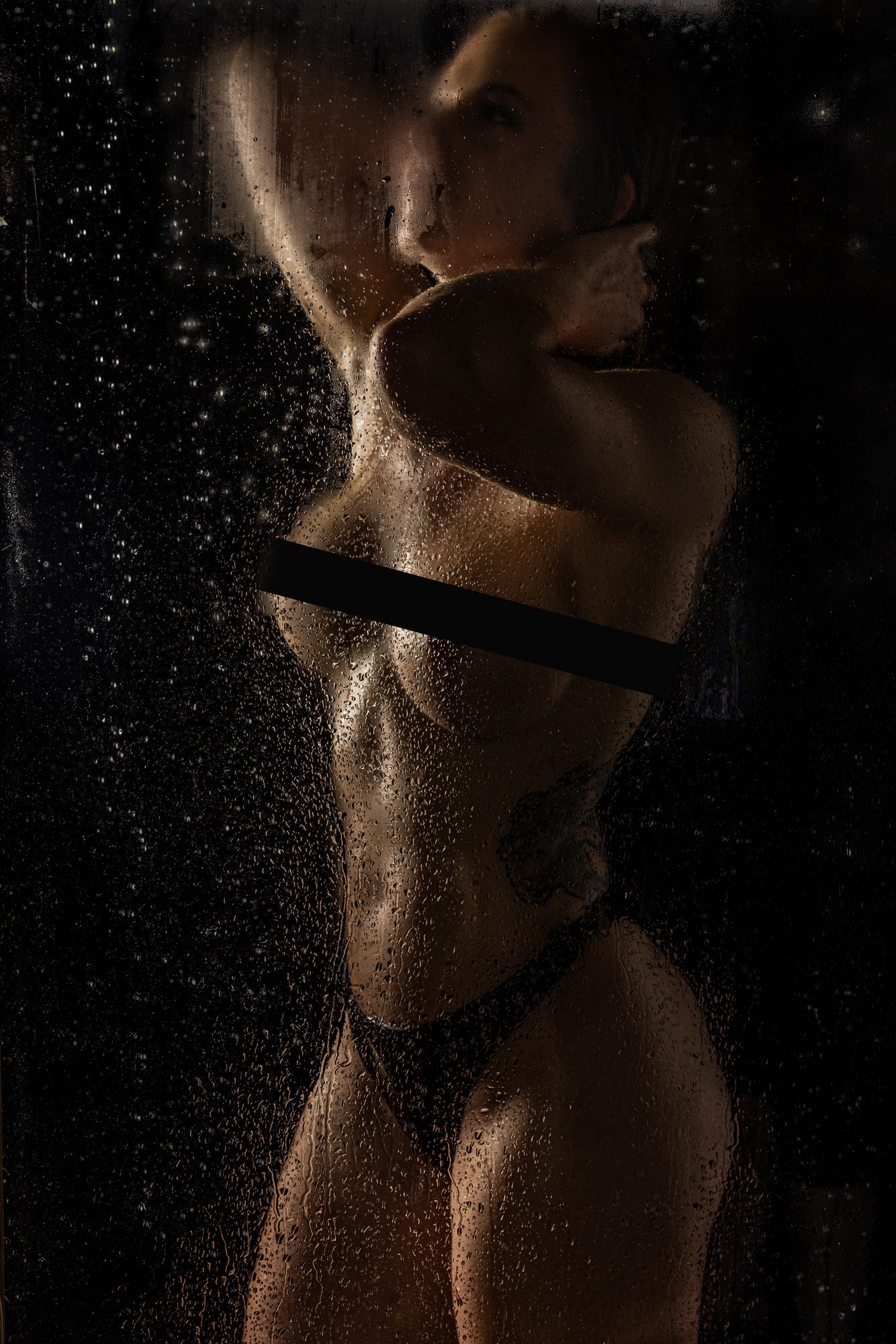 Artistic boudoir silhouette behind a fogged shower glass panel, captured with moody lighting and soft steam for a cinematic, sensual aesthetic.