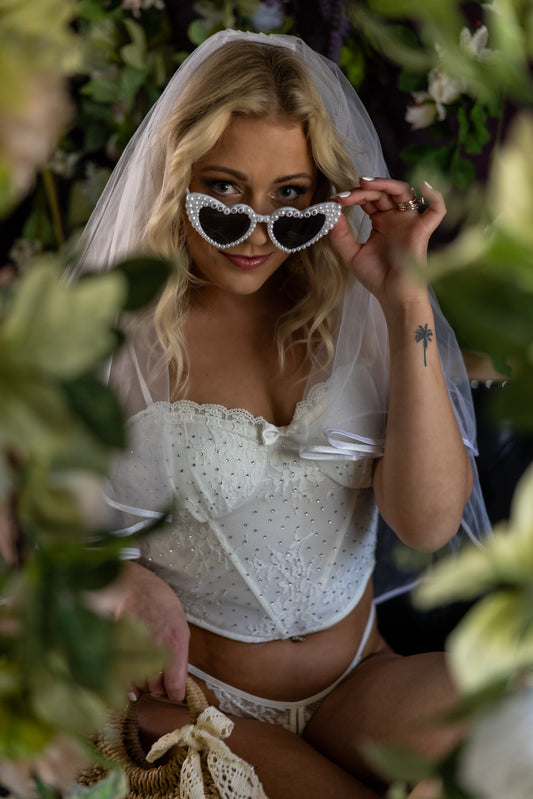 Bridal boudoir portrait featuring a woman wearing a veil and pearl sunglasses, captured in Appleton, Wisconsin with soft studio lighting for a playful yet elegant bridal aesthetic.