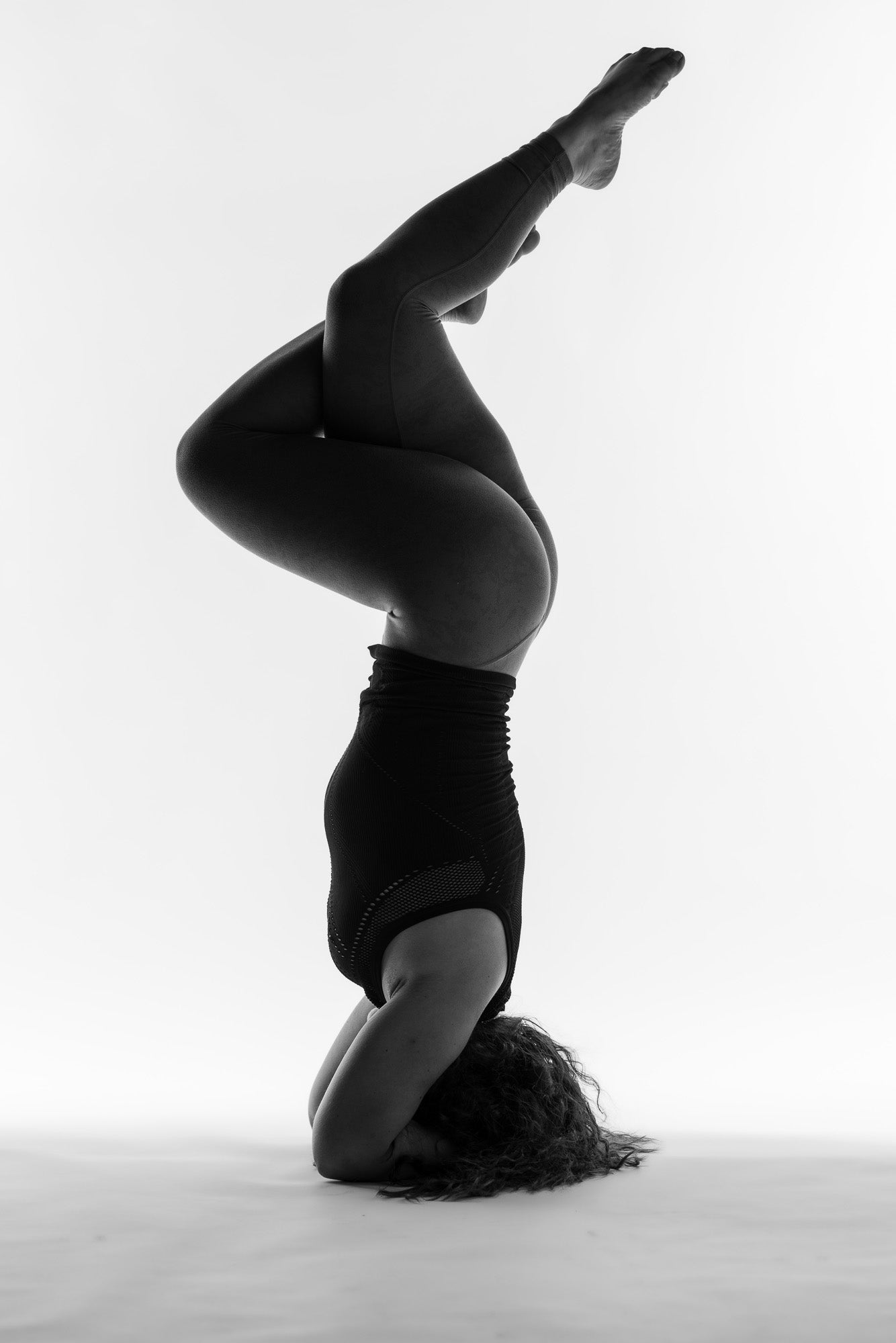 Artistic black-and-white handstand boudoir shot.